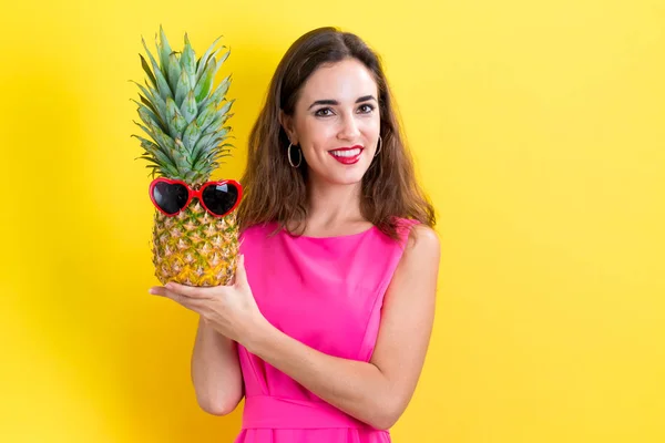 Glückliche junge Frau in der Hand einer Ananas — Stockfoto