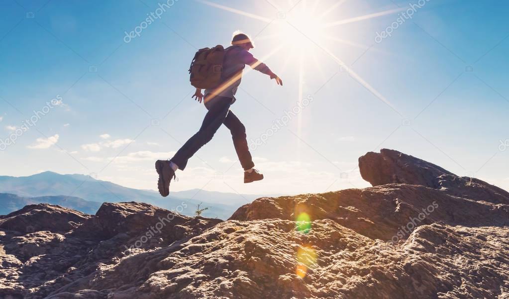 Man jumping over gap on mountain hike