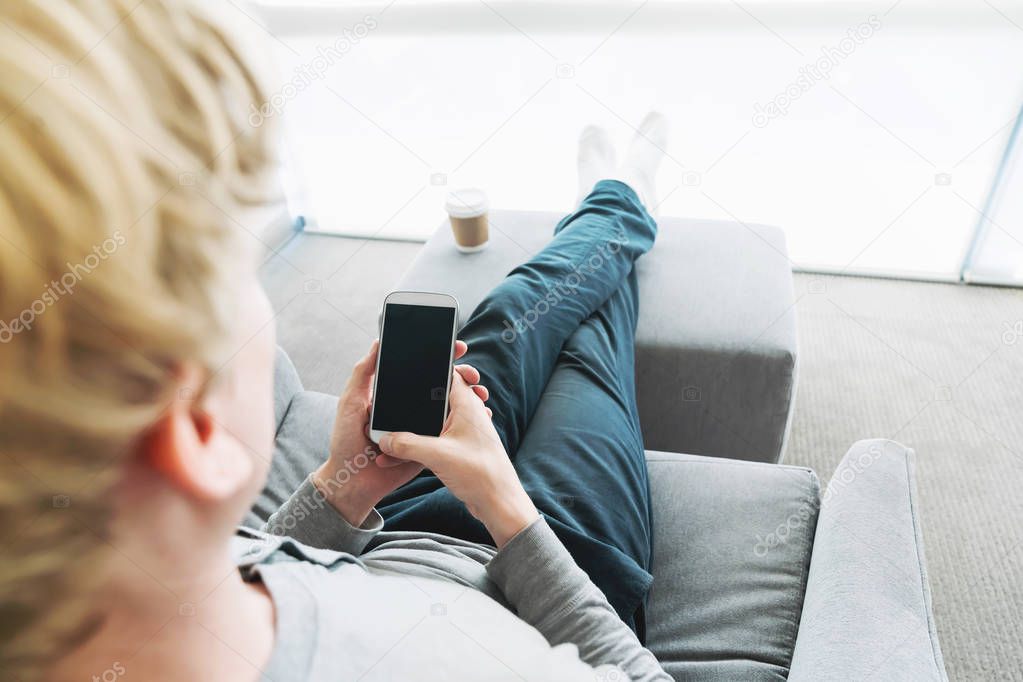 Person relaxing and using smart phone