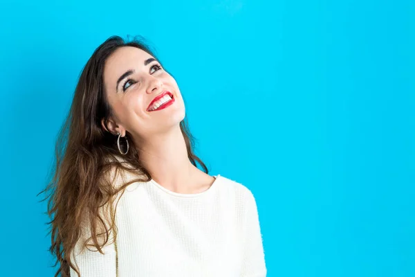 Boldog, fiatal nő, kék háttérrel — Stock Fotó