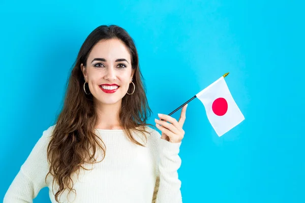 Young woman holding Japanese flag