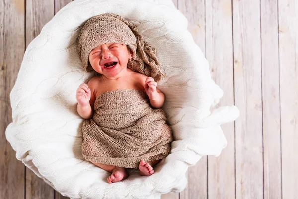 Huilende babyjongen in een mandje — Stockfoto