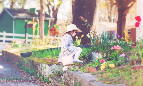 Ragazza bambino in un cappello esplorare il suo giardino primaverile — Foto Stock