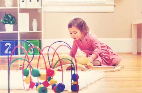 Feliz niña jugando con su osito de peluche —  Fotos de Stock