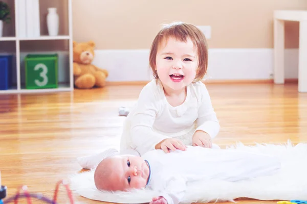 Joyeux tout-petit fille avec sa sœur nouveau-née — Photo