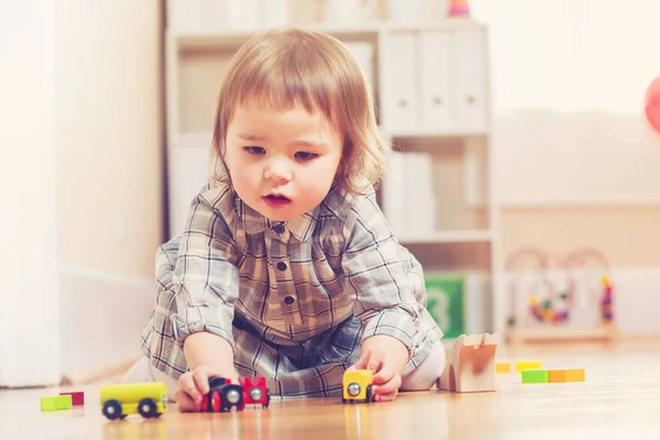 Ευχαρίστως toddler κορίτσι παίζει με τα παιχνίδια — Φωτογραφία Αρχείου