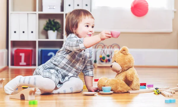 Happy toddler girl playing with bear — Stock Photo, Image