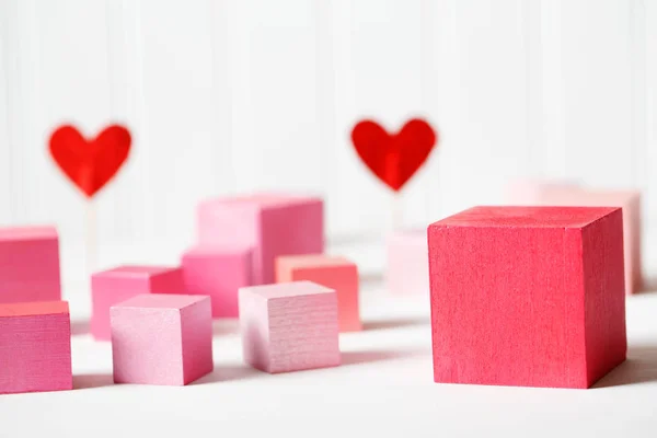 Red and pink wooden blocks with small hearts — Stock Photo, Image