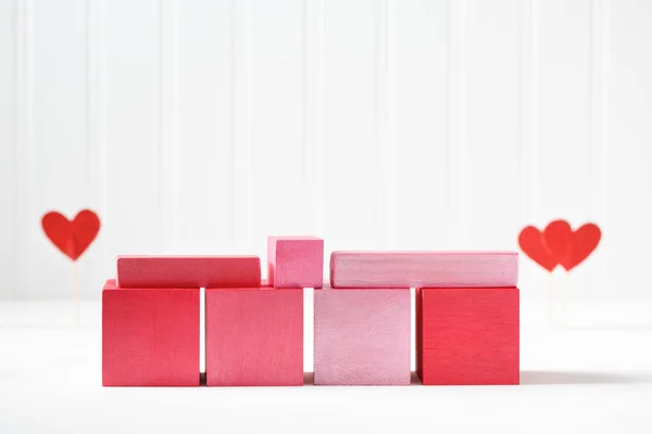 Red and pink wooden blocks with small hearts — Stock Photo, Image