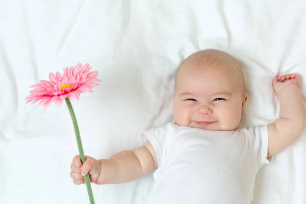 Niña recién nacida feliz con una flor — Foto de Stock