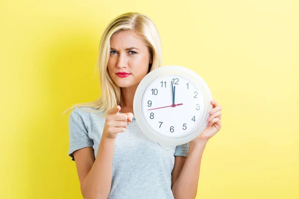 Woman holding clock showing nearly 12 — Stock Photo, Image