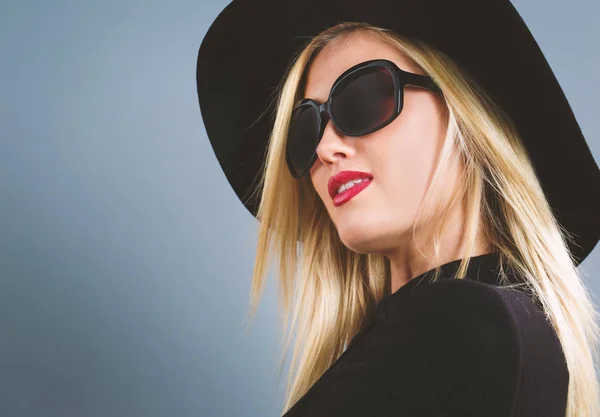 Beautiful young blonde woman in a black coat — Stock Photo, Image