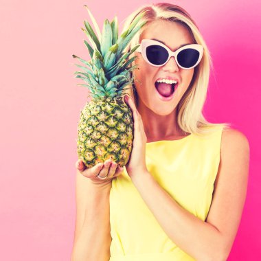 Bir ananas tutan mutlu genç kadın