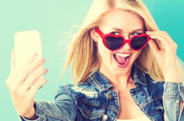 Genç bir kadın selfie çekiyor. 