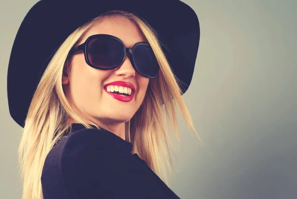 Mooie jonge blonde vrouw in een zwarte jas — Stockfoto
