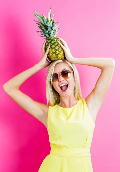 Glad ung kvinna håller en ananas — Stockfoto