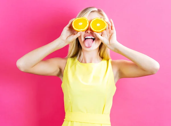 Щаслива молода жінка тримає оранжеві половинки — стокове фото