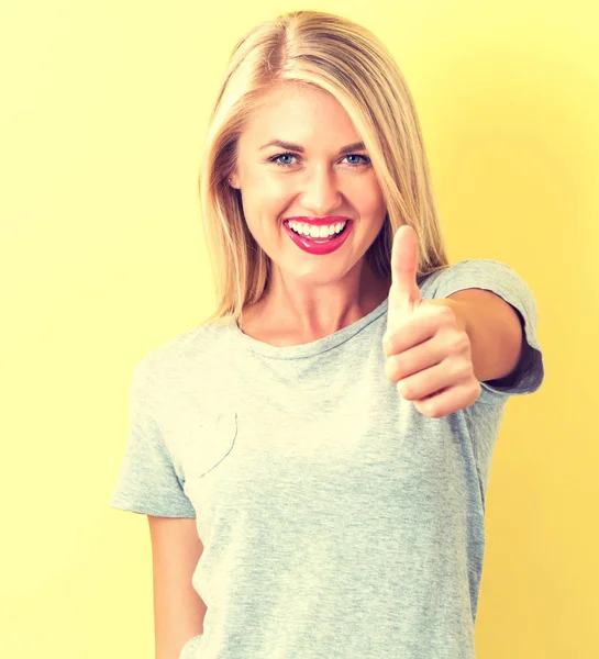 Boldog fiatal nő felemeli a hüvelykujját — Stock Fotó