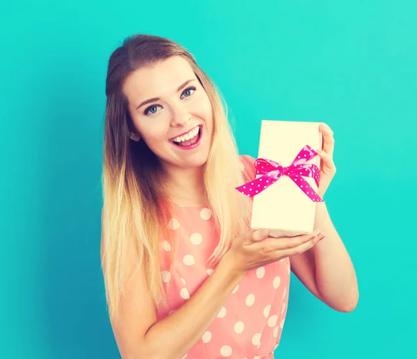 Happy young woman holding a gift box — Stock Photo, Image