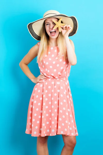 Happy young woman holding a starfish — Stock Photo, Image