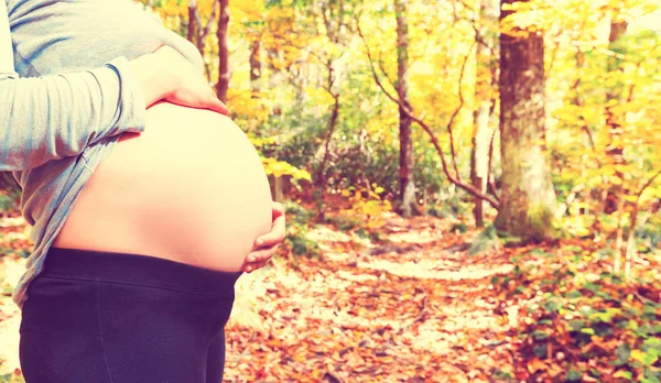 妊娠中の女性が彼女の腹を屋外開催 — ストック写真