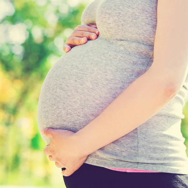 Беременная женщина стоит на улице — стоковое фото