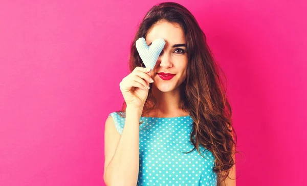 Mujer joven feliz sosteniendo un cojín del corazón —  Fotos de Stock