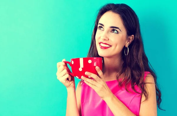 Счастливая молодая женщина пьет кофе — стоковое фото