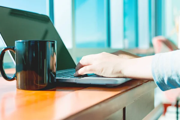 Женщина, работающая на ноутбуке в светлой комнате — стоковое фото