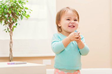 Tebeşir ile oynarken mutlu yürümeye başlayan çocuk kız 