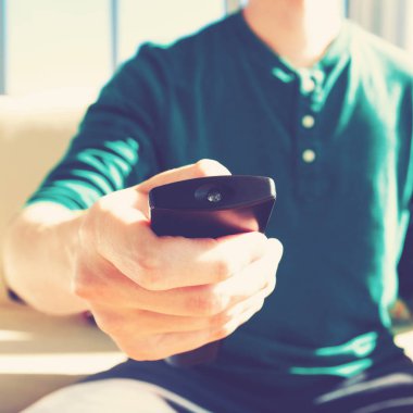 Genç adam uzaktan kumanda kullanıyor.