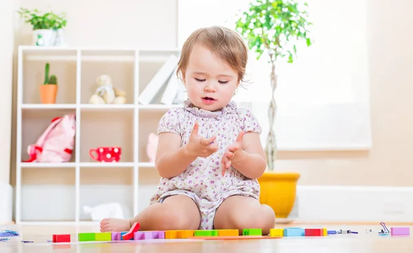Happy toddler girl playing with her toys — Stock Photo, Image