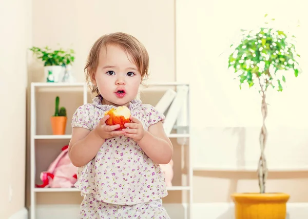 Ευχαρίστως toddler κορίτσι τρώει ένα μήλο — Φωτογραφία Αρχείου