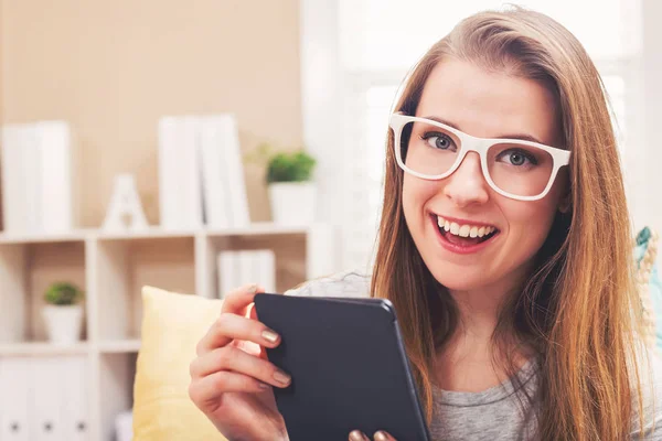 Mujer joven y feliz leyendo un libro electrónico —  Fotos de Stock