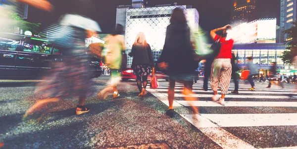 Motion blurred people walking at night — Stock Photo, Image