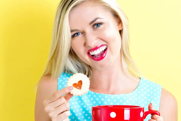 Glückliche junge Frau mit Keksen und Kaffee — Stockfoto