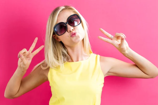Young woman giving the peace sign — Stock Photo, Image