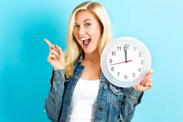 Woman holding clock showing nearly 12 — Stock Photo, Image