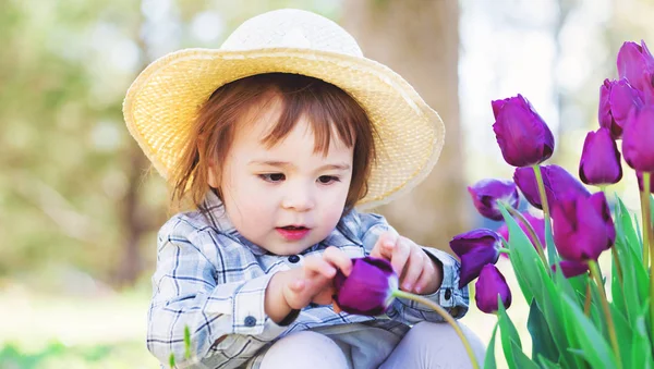 Mädchen spielt mit Tulpen — Stockfoto