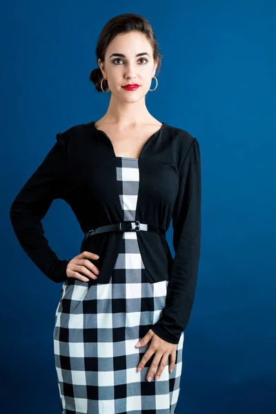 Woman standing in checkered dress — Stock Photo, Image