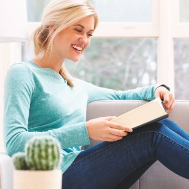 Kadın evde kitap okuyor.