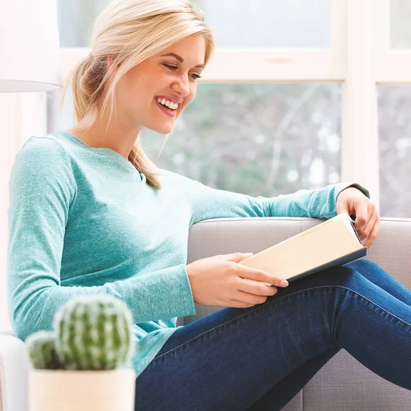 Kadın evde kitap okuyor.