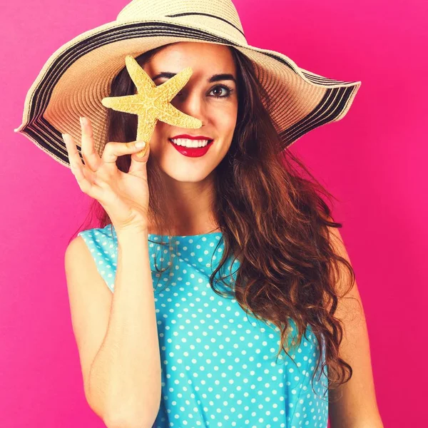 Gelukkig jonge vrouw bedrijf starfish — Stockfoto