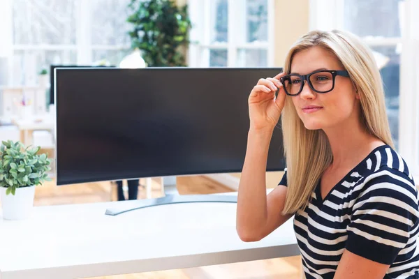 woman sitting in front of big monitor