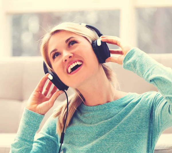 Femme écoutant de la musique sur écouteurs — Photo