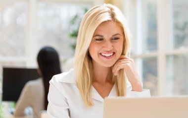 Masasında oturan mutlu genç kadın