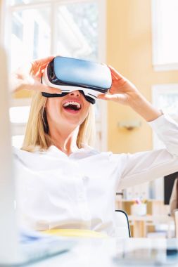 Sanal gerçeklik kulaklığı kullanan genç bir kadın.