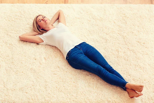 Mujer joven acostada en la alfombra —  Fotos de Stock