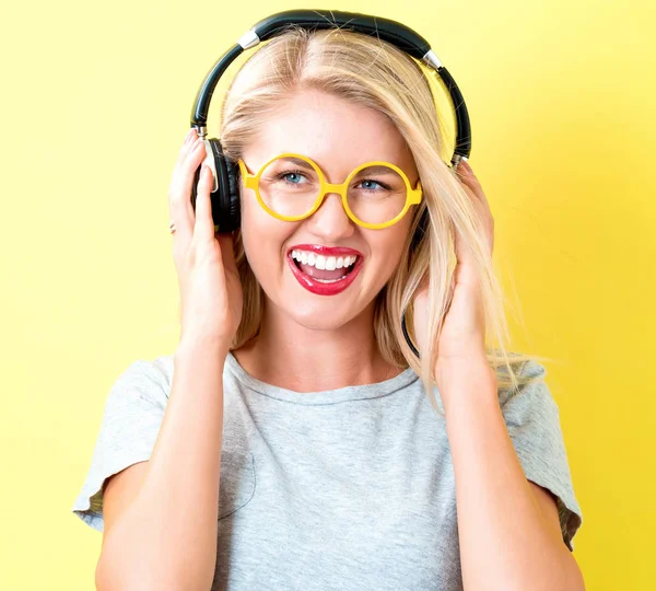 Щаслива молода жінка з навушниками — стокове фото