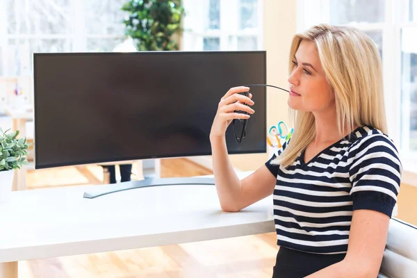 Young woman sitting in front of big monitor